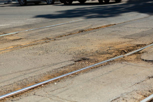 разбитая асфальтовая дорога возле трамвайной трассы. - pot hole street car hole стоковые фото и изображения