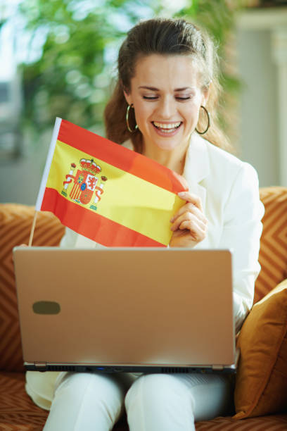 istock woman with laptop and Spanish flag teaching foreign language 1224619373