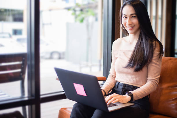 istock Asian businesswomen are using notebook computers for working from home. She smiles happy and enjoys working. 1224621751