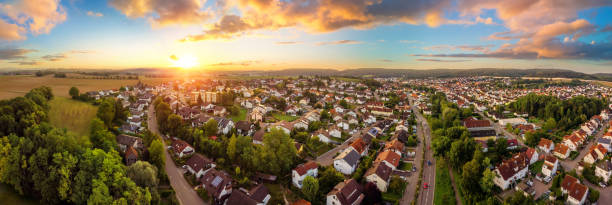 Aerial panorama of small town at sunrise Aerial panorama of a small town at sunrise, with magnificent colorful sky and warm light sunrise germany stock pictures, royalty-free photos & images