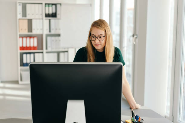 istock Young businesswoman standing at her computer 1224622459