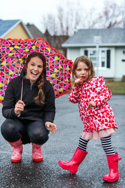 istock 4 years little girl jumping in puddle 1224623682