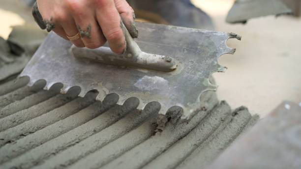 le travailleur travaille avec une spatule. outils avant encoché truelle. mains d’un vieil ouvrier manuel avec des outils de plâtrage de mur rénovant la maison. plasterer rénovant les murs et les coins extérieurs avec spatule et plâtre. isolation mu - plasterer plaster wall dirty photos et images de collection