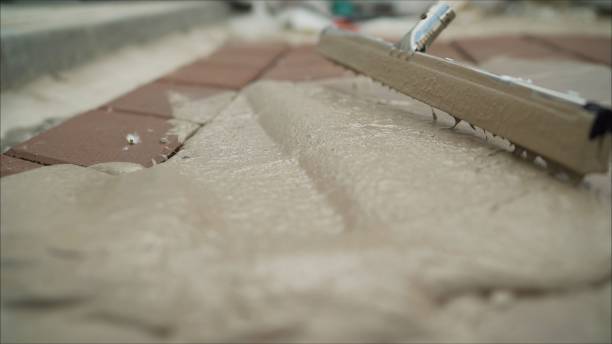 istock Man at work who is putting the asphalt. Laying pavers with a solution. 1224628532