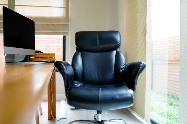 istock Black working chair and mornitor near window at home, working space with blurred table on foreground.Working from home to avoid corona virus.Social distancing and stays at home safe from COVID-19 infection. 1224629307
