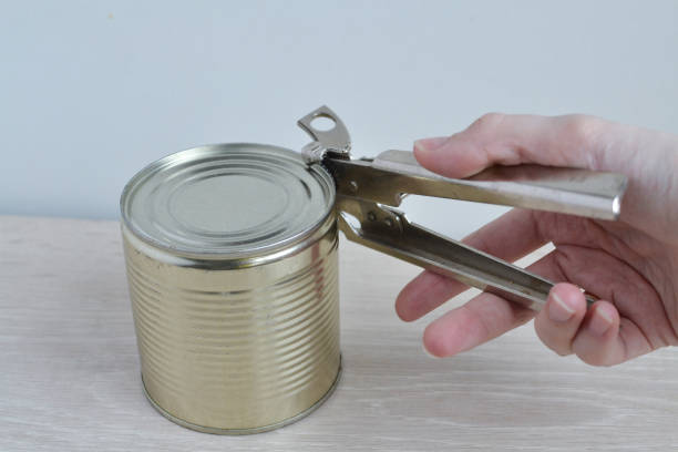 istock Open a metal can with a can opener close-up. 1224632076