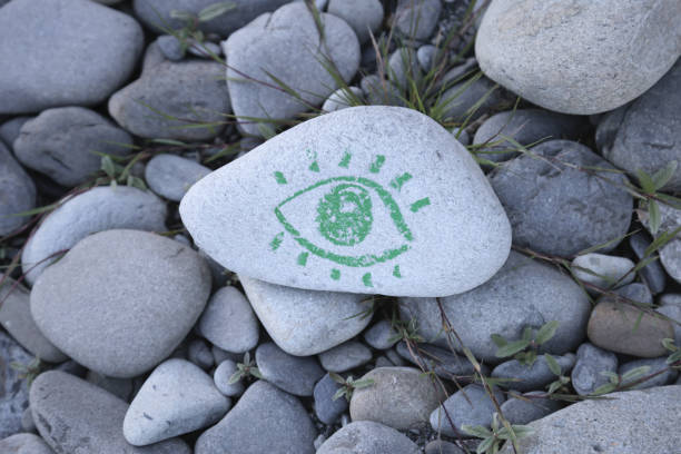 Green eye drawing on a stone