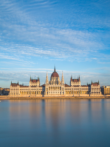 The outside of the Hungarian Parliament Building towards sunset. Reflections can be seen in the water.