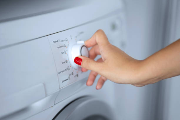 istock The girl sets the washing program for the washing machine 1224636335