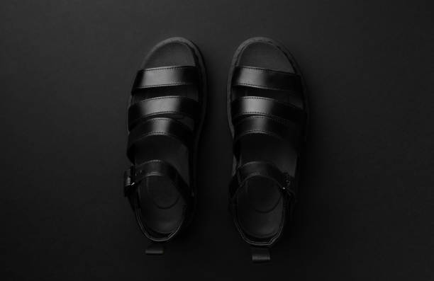 istock Flat lay top view minimal monochrome composition with sandals on black background 1224636355