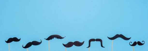 istock Various black photo booth props moustaches of different shape on blue background. Greeting card for father's day or men's health awareness month campaign concept. Flat lay, banner 1224637616