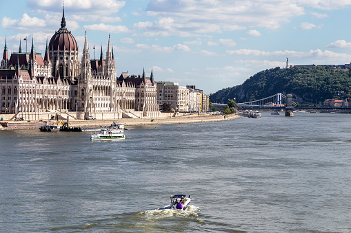 View of the building of the Hungarian Parliament, the Danube River, bridges and ships on a sunny summer day. Budapest, Hungary.