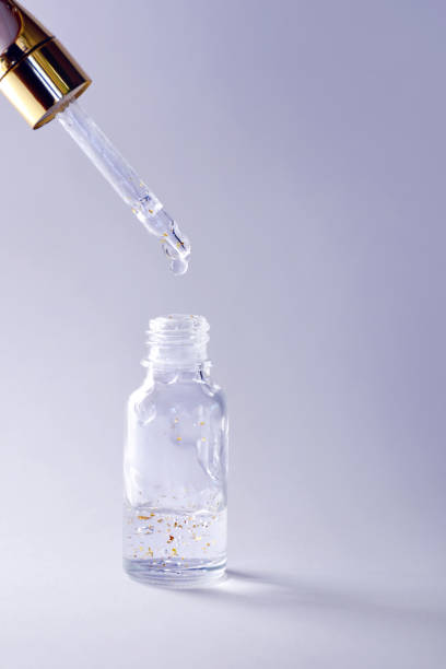 istock Gold particles glittering serum bottle with dropper 1224642822