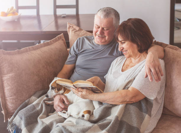 istock Happy elderly couple sitting on sofa at home 1224642825