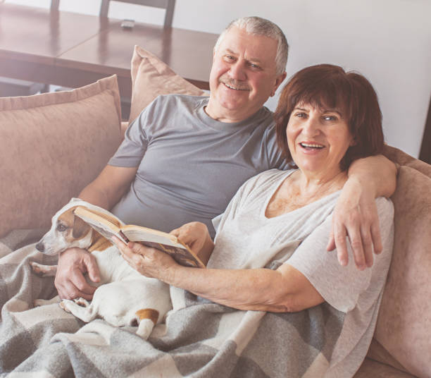 istock Happy elderly couple sitting on sofa at home 1224642835