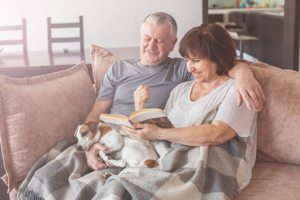 istock Happy elderly couple sitting on sofa at home 1224642847