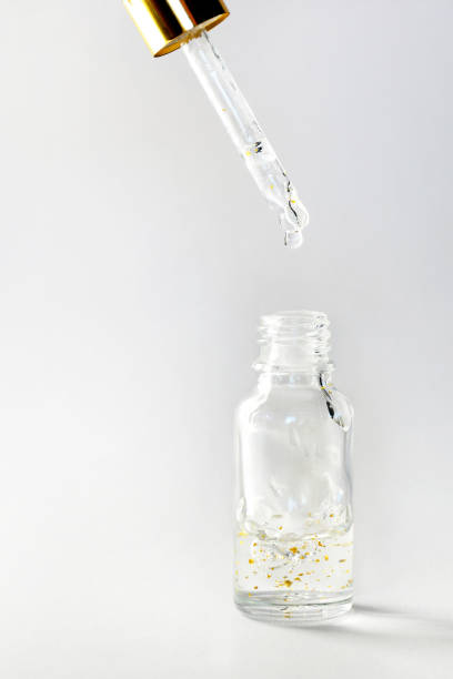 istock Gold particles glittering serum bottle with dropper 1224642980