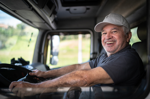 Portrait of a senior male truck driver sitting in cab
