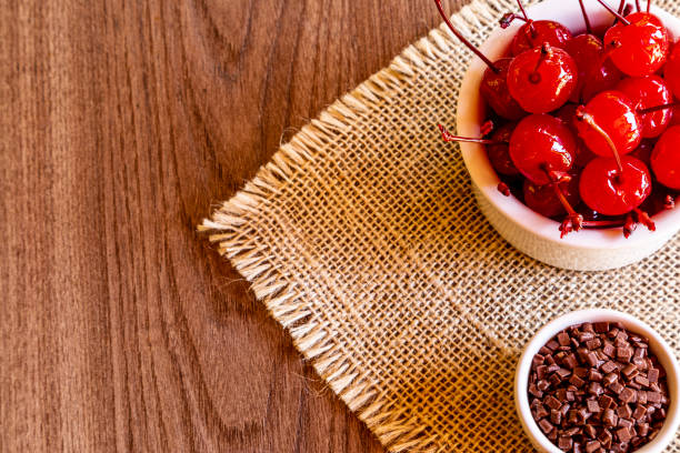 Delicious cherries in bowl on wooden background