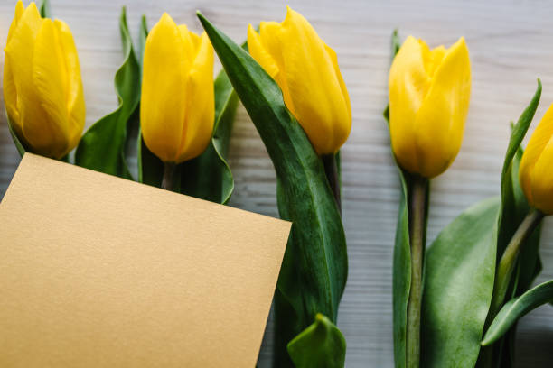 istock Craft postcard on yellow tulips on wooden background. Space for message. Concept Hello Spring flowers. Holiday greeting card for Valentine's, Women's, Mother's Day, Easter! Top view, flat lay. 1224646592