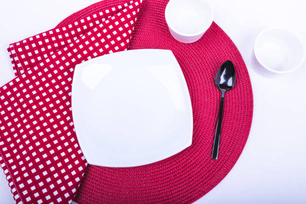 istock a square plate with a spoon set on a red-and-white tablecloth 1224649234