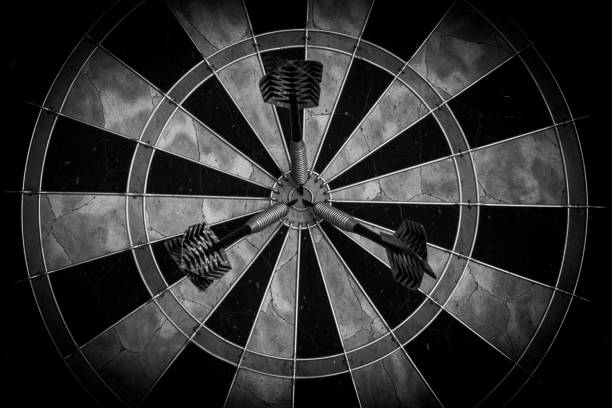 дартборд с тремя дартами в яблочко - черно-белый - dartboard bulls eye darts pattern стоковые фото и изображения