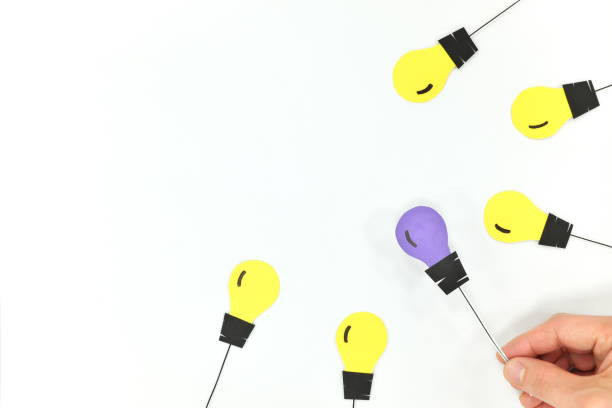istock Unique, new and original business idea concept. Hand choosing a different color light bulb. 1224656078