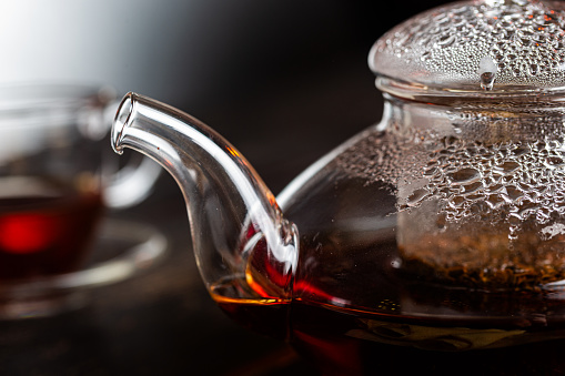 Black tea in a transparent teapot close-up