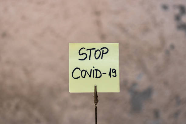 istock Stop covid-19 handwriting text on memo post reminder isolated with copy space. 1224659705