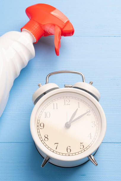 istock Alarm clock and spray with a red dispenser on a light blue wooden background 1224660446