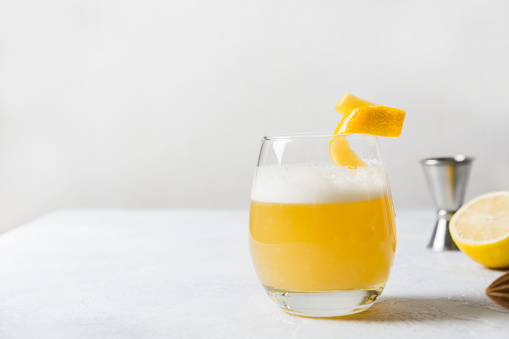 Whiskey sour cocktail with ingredients on white table. Horizontal orientation. Homemade drink. Close up. Space for text.