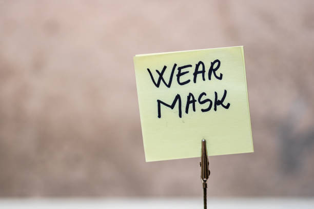 istock Wear mask handwriting text on memo post reminder isolated with copy space. 1224661850