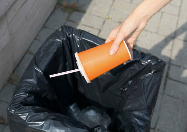 istock Ecology, environment, recycling concept - hand throwing plastic cup in trash can on the city street 1224662469