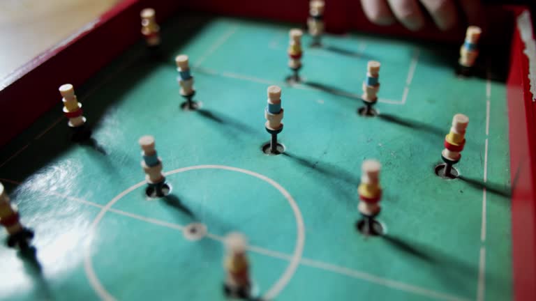 Two little boys playing with and old soccer game toy