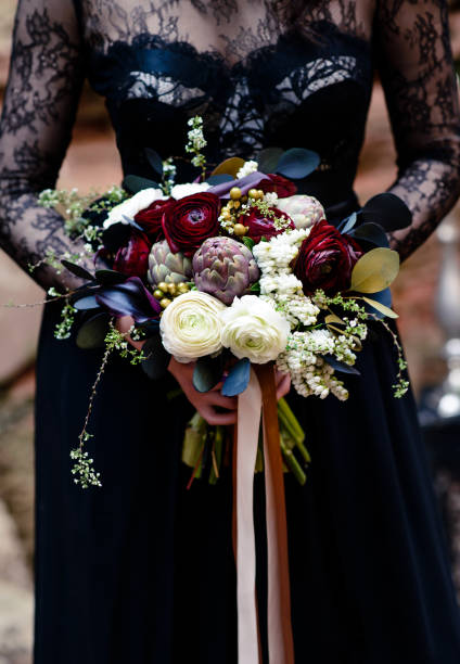 bouquet dans les mains d’une fille dans une robe noire. noir magique, beauté gothique. halloween, bouquet de veuve noire - goth photos et images de collection