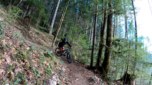 istock Female mountain biker rides along forested path 1224667717