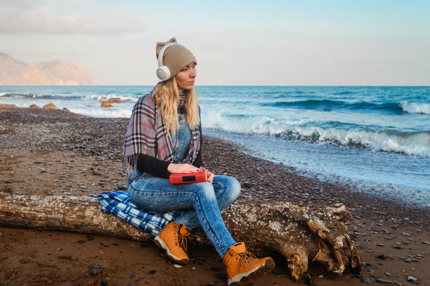 istock Girl on the seashore reads a book 1224671358