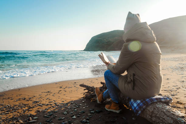 istock Girl on the seashore reads a book 1224671495