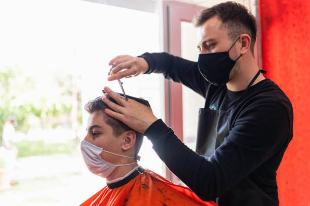 young man getting haircut at the barbershop young man getting haircut at the barbershop men hair cut stock pictures, royalty-free photos & images