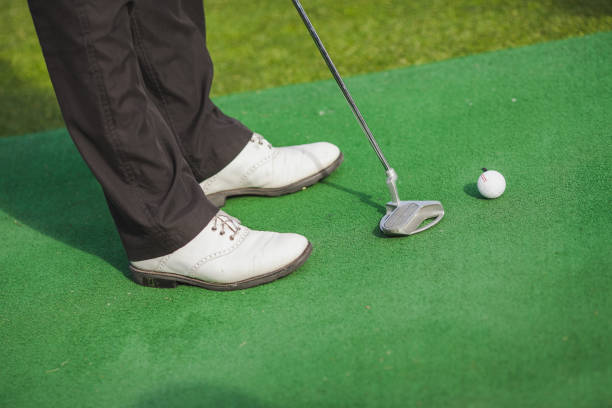 istock Side view of a golf ball lying on an green lawn 1224677615