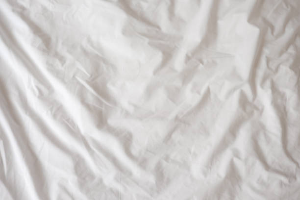 istock Background of white rumpled sheets. Bed linen with wrinkles in day light. Horizontal. Copy spase. Concept of rest, awakening, sleep, stay at home. For social media, blog 1224677692