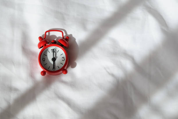 istock Red analog clock on white rumpled sheets. Top view, flat lay, copy space. Horizontal. Concept of awakening, sleep, early rise, productivity, productive day. For social media, blog. Minimal style 1224677694