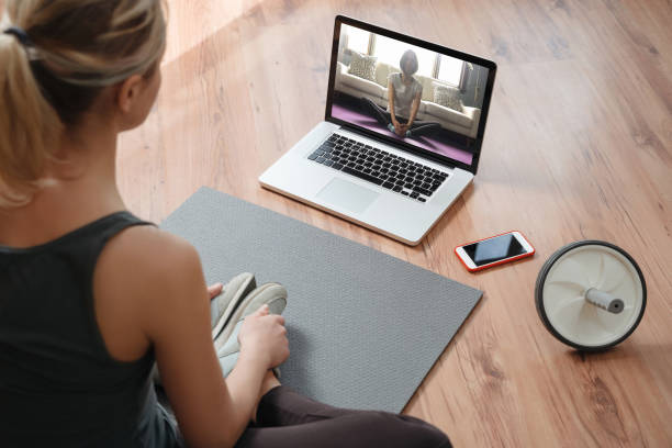 istock Young woman practicing yoga at home with latop 1224677709