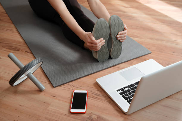 istock Young sporty woman training at home using laptop 1224677808