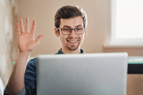 istock Smiling young guy having video call at home 1224677915