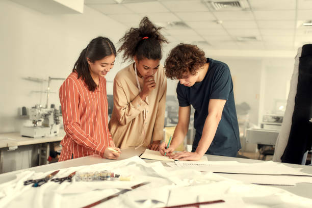 istock Look good with us. Young cheerful designers working together in a studio. Group of creative millennials sharing and discussing ideas 1224679259