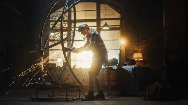 Talented Innovative Tomboy Female Artist Uses an Angle Grinder to Make an Abstract, Brutal and Expressive Metal Sculpture in a Workshop. Contemporary Fabricator Creating Modern Steel Art.
