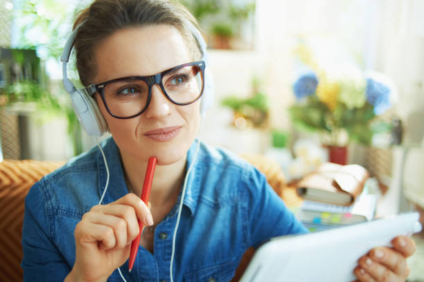 istock smiling woman with white headphones and tablet PC study online 1224683922