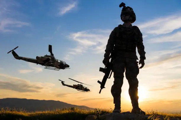 Military Helicopters and Army Soldier at sunset