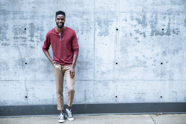 istock Cheerful Black Male Standing by a Concrete Wall 1224689451